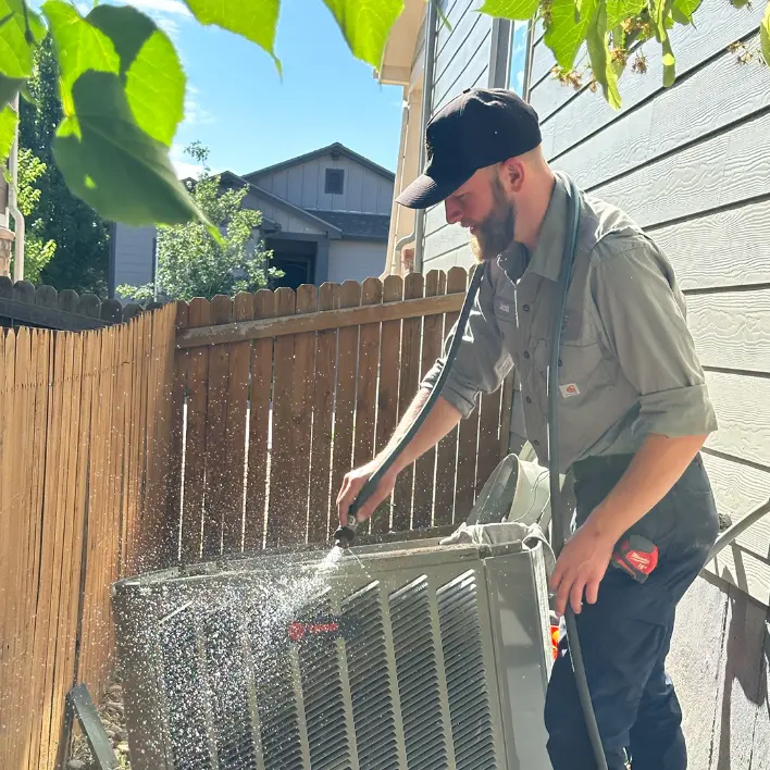 HVAC technician performing AC maintenance to help prevent system breakdowns