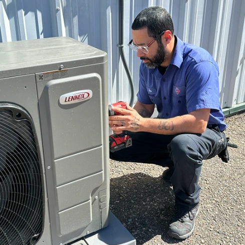 HVAC technician performing AC maintenance to help prevent system breakdowns